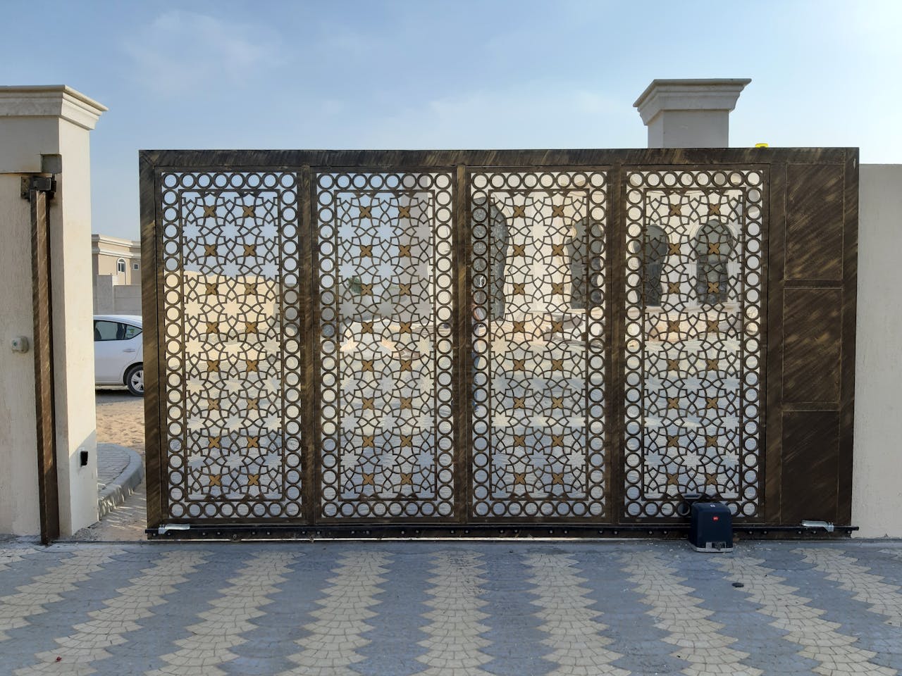 heros-img A beautiful patterned gate contrasts the Dubai landscape, capturing modern elegance.